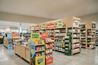 Vue large d'une allée de supermarché avec divers accessoires de PLV disposés le long des gondoles